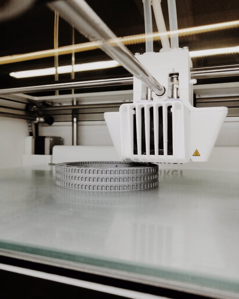 Boquilla de impresora 3D depositando las primeras capas de una pieza redonda